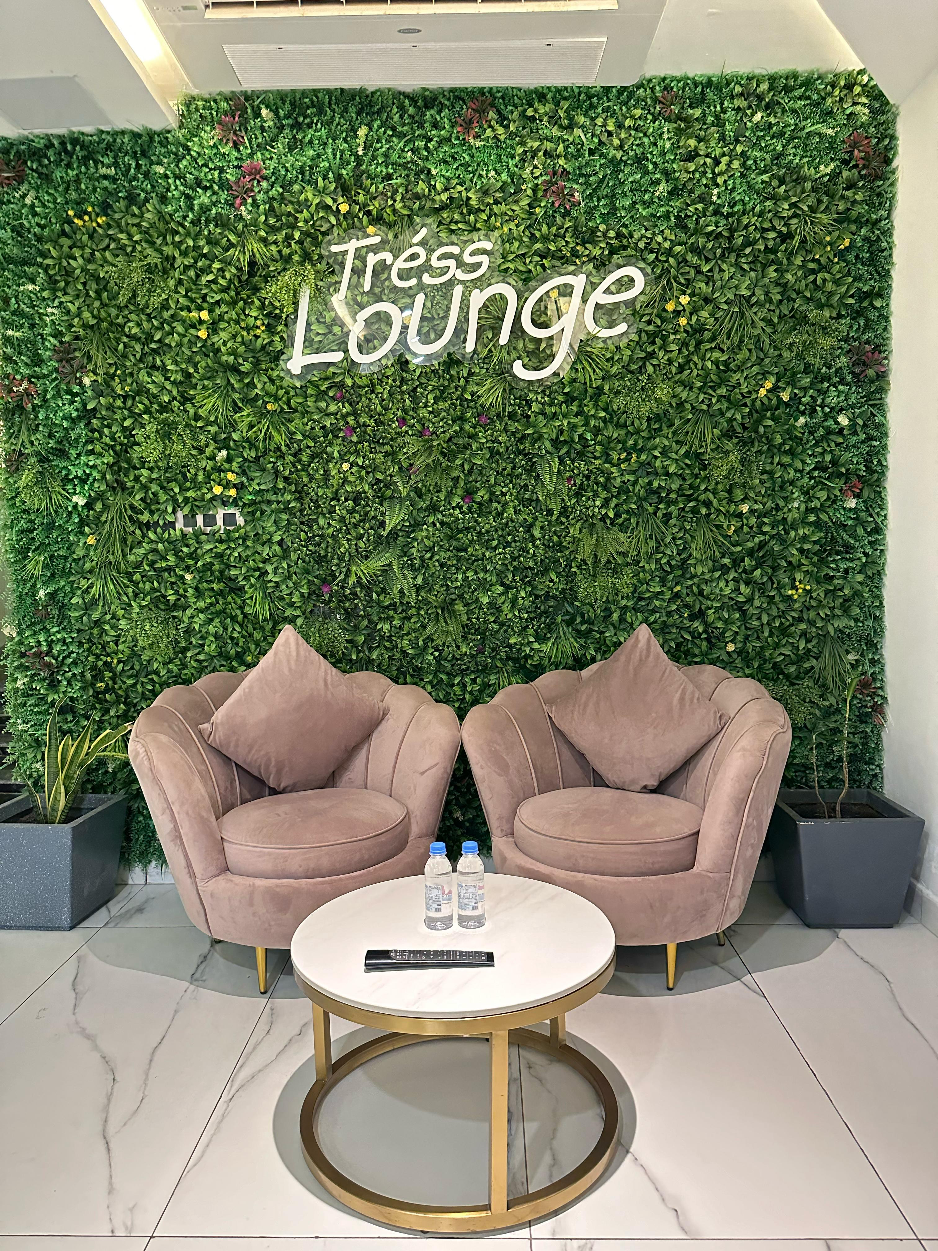 Tress Lounge green welcome wall and lounge seating